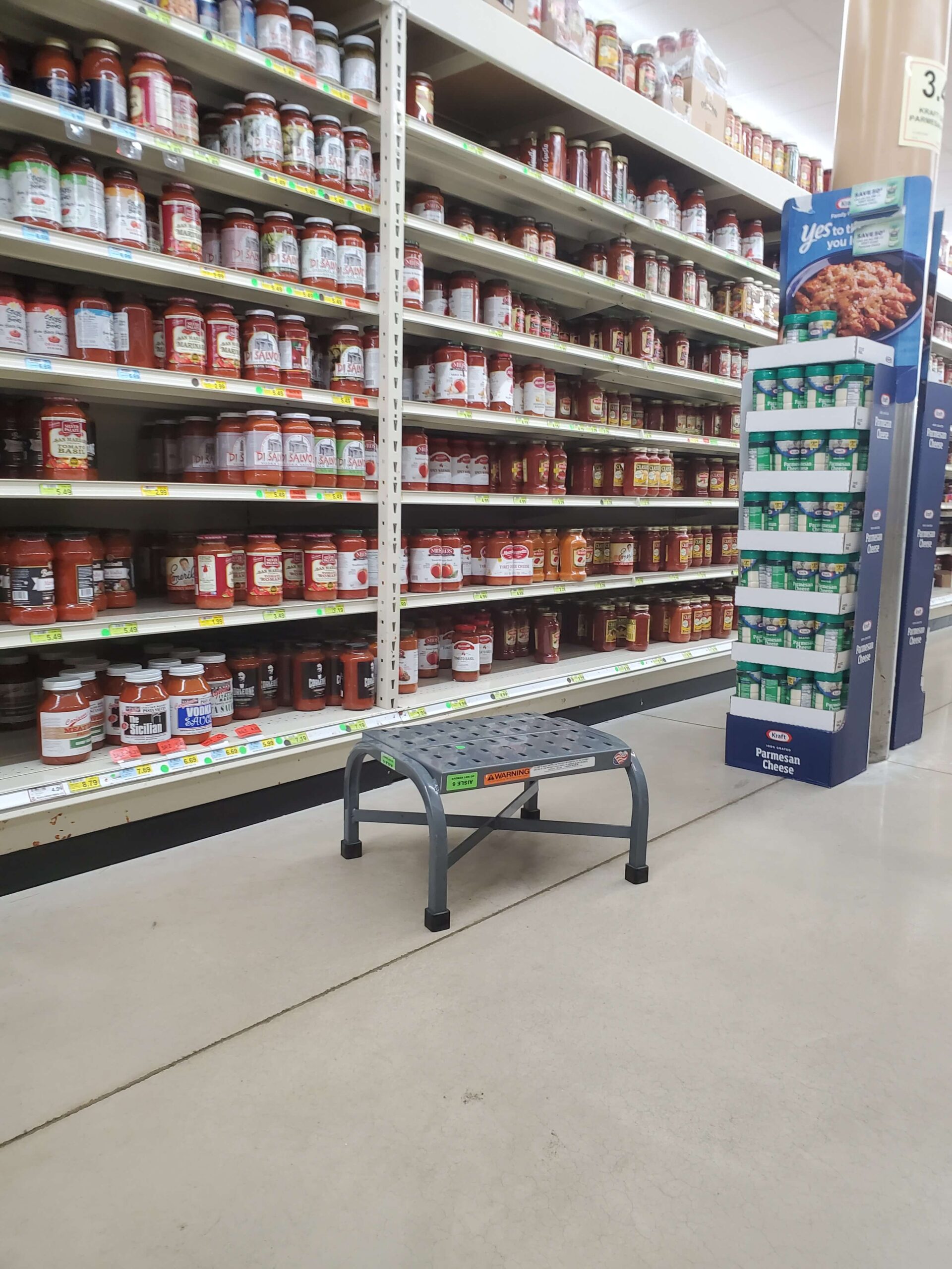 PSS perforated step stool on the ground near pasta sauce aisle in grocery store